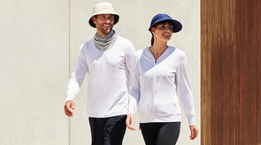 A man and woman walking wearing sun hats and sun protective clothing